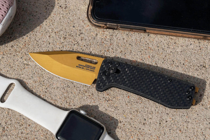 Couteau pliant SOG Ultra XR Gold SGULTRAXRGD manche en fibre de carbone noir 9,1cm
